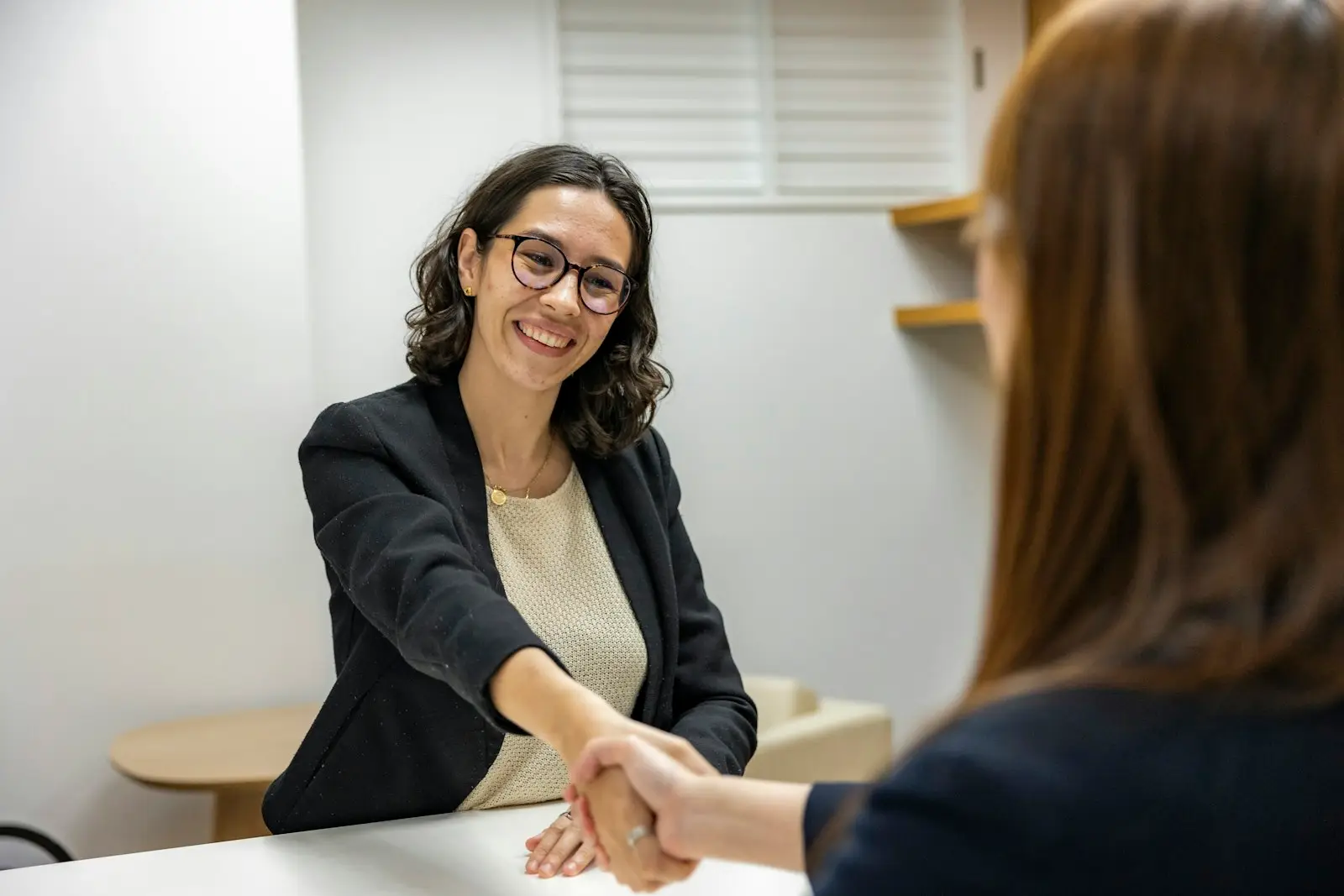 Recruteuse souriante serrant la main d’une candidate